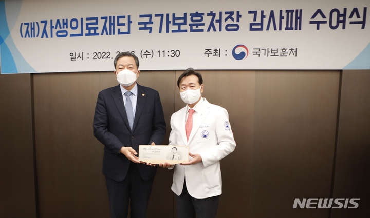 [서울=뉴시스]신준식 자생의료재단 명예이사가 국가보훈처 황기철 처장으로부터 감사패를 받은 뒤 기념촬영을 하고 있다. (사진= 자생한방병원 제공) 2022.02.16