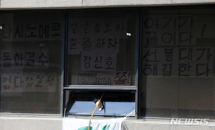 [서울=뉴시스] 조성우 기자 = 16일 오전 서울 중구 CJ대한통운 본사에서 점거 농성중인 전국택배노동조합 조합원이 창문을 닦고 있다. 2022.02.16. xconfind@newsis.com