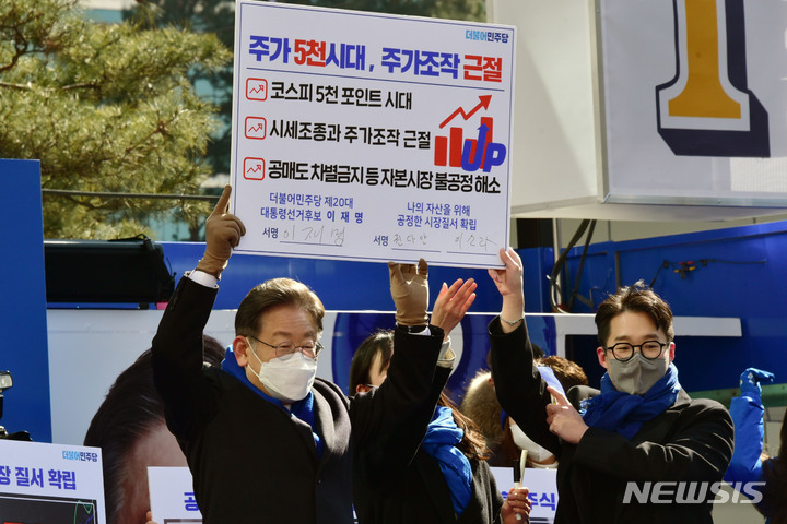 [서울=뉴시스] 국회사진기자단 = 이재명 더불어민주당 대선 후보가 16일 서울 강남구 강남역 인근에서 열린 'JM은 강남스타일!' 선거 유세를 마친 뒤 주가 5천 시대, 주가조작 근절 서약을 하고 있다. 2022.02.16. photo@newsis.com