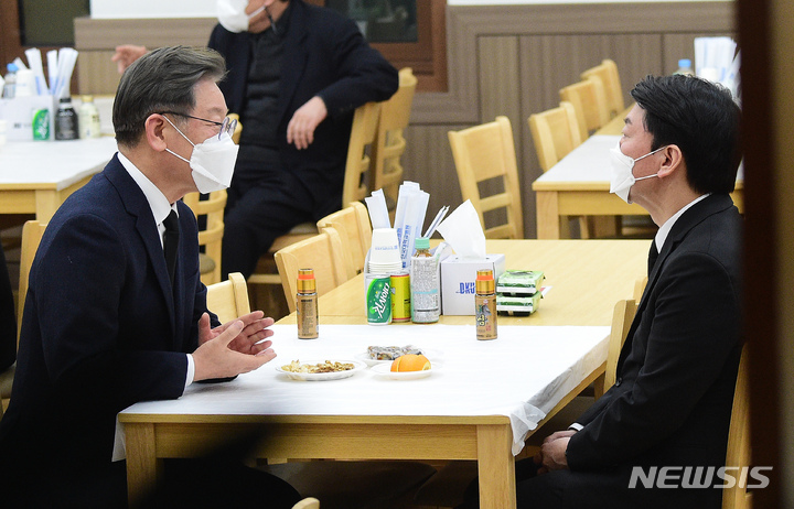 [천안=뉴시스] 전신 기자 = 이재명 더불어민주당 대선 후보가 16일 충남 천안 단국대학교병원 장례식장에 마련된 고 손평오 국민의당 논산·계룡·금산 지역 선거대책위원장 빈소를 조문, 안철수 국민의당 대선 후보와 대화하고 있다. 2022.02.16. photo1006@newsis.com