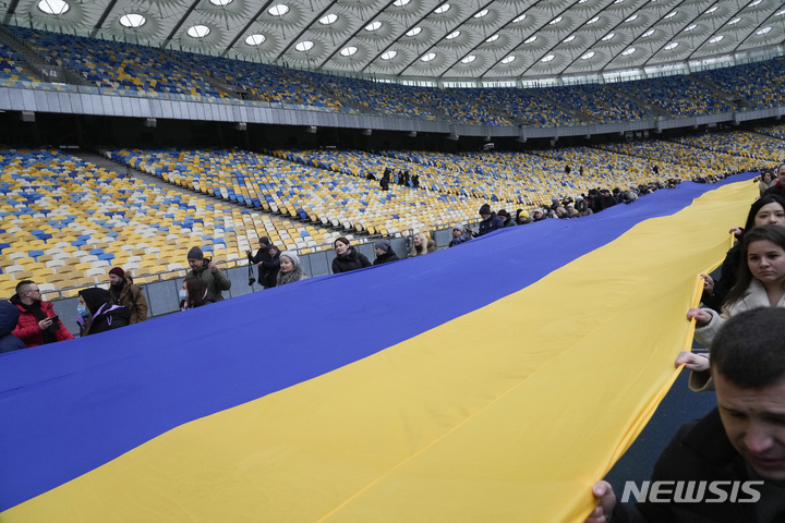 [키예프=AP/뉴시스] 16일(현지시간) 우크라이나 키예프의 올림피스키 경기장에서 시민들이 '단결의 날'을 기념해 길이 200m의 우크라이나 국기를 펼쳐들고 있다. 볼로디미르 젤렌스키 우크라이나 대통령은 미국이 예상한 러시아 침공일인 16일을 '단결의 날'로 선포했다. 2022.02.17.