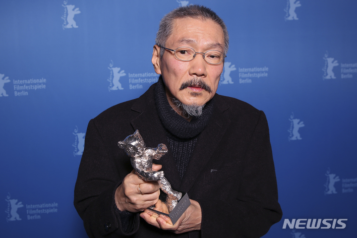 [베를린=AP/뉴시스]16일(현지시간) 베를린 국제영화제에서 '소설가의 영화'로 심사위원 대상을 수상한 홍상수 감독이 트로피를 들고 포즈를 취하고 있다. 2022.2.17