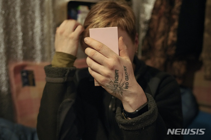 [포파스나=AP/뉴시스] 16일(현지시간) 우크라이나 동부 루한스크주 포파스나 외곽 최전방 진지에서 한 우크라이나군 병사가 거울을 보며 매무새를 다듬고 있다. 나토(NATO·북대서양조약기구)는 러시아의 병력 일부 철수 주장에도 러시아가 우크라이나 접경에서 철수하지 않았다고 밝혔다. 2022.02.17.