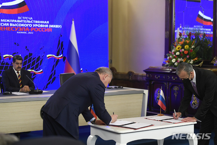 [카라카스=AP/뉴시스] 유리 보리소프(가운데) 러시아 부총리와 타렉 엘 아이사미 베네수엘라 석유장관이 16일(현지시간) 베네수엘라 카라카스의 대통령궁에서 니콜라스 마두로 대통령이 지켜보는 가운데 협정서에 서명하고 있다. 2022.02.17.