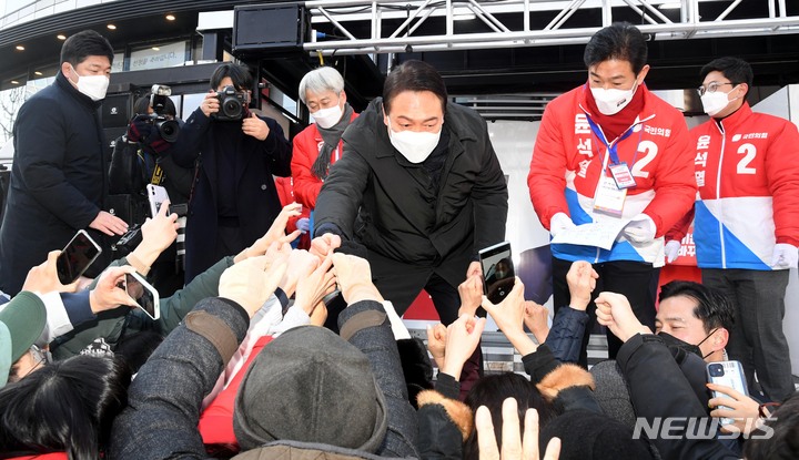 [서울=뉴시스] 국회사진기자단 = 윤석열 국민의힘 대선 후보가 17일 서울 송파구 석촌호수 서호 인근 사거리에서 유권자들을 향해 지지를 호소하고 있다. 2022.02.17. photo@newsis.com
