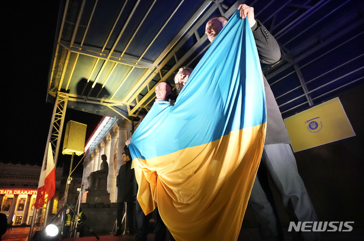 [바르샤바=AP/뉴시스] 17일(현지시간) 폴란드 바르샤바에서 시민들이 이웃 국가인 우크라이나 국기를 들고 우크라이나 지지 집회에 참석하고 있다. 폴란드는 러시아의 침공 우려가 있는 우크라이나에 연대를 표명하고 있다. 2022.02.18.