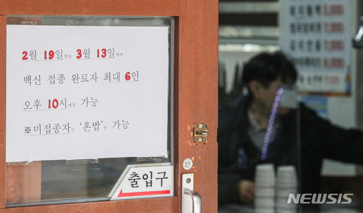 [서울=뉴시스] 권창회 기자 = 정부가 사회적 거리두기 방침을 일부 완화한 지난 18일 오후 서울 시내 한 식당에 새로운 거리두기 안내문이 붙어있다. 오는 19일부터 다음달 13일까지 개편되는 방역체계에 따라 '사적모임 6인, 오후 10시'로 완화된다. 2022.02.18. kch0523@newsis.com