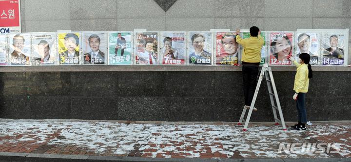 [광주=뉴시스] 류형근 기자 = 18일 오후 광주 북구 운암동 모 아파트 벽에 운암1동행정복지센터 직원들이 제20대 대통령선거 후보자들의 '선거벽보'를 부착하고 있다. 2022.02.18. hgryu77@newsis.com