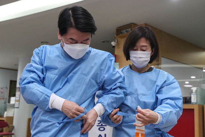 [서울=뉴시스] 이영환 기자 = 안철수 국민의당 대선 후보와 부인 김미경 교수가 19일 서울 중구보건소 선별진료소에서 의료 자원봉사에 앞서 방역복을 착용하고 있다. (공동취재사진) 2022.02.19. photo@newsis.com