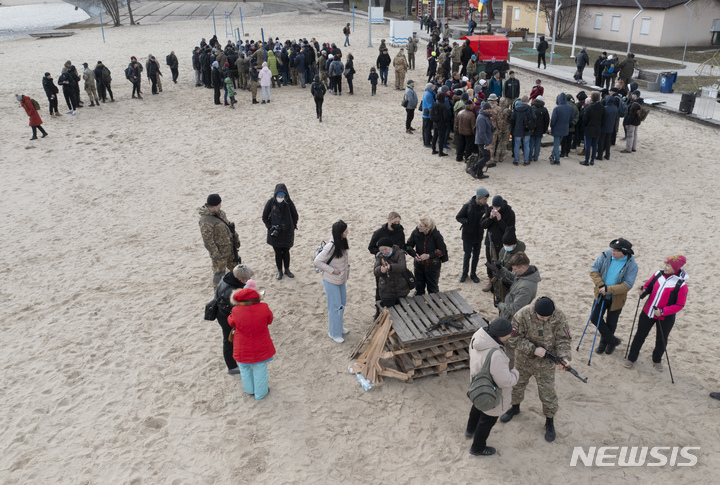 [키예프=AP/뉴시스] 20일(현지시간) 우크라이나 키예프의 한 공원에 모인 민간인들이 무기 다루는 법을 배우고 있다. 러시아가 우크라이나 동부 돈바스 지역의 상황 악화를 구실로 20일 종료 예정이던 벨라루스와의 합동 군사훈련을 연장해 우크라이나 침공에 대한 긴장이 고조되고 있다. 2022.02.21.