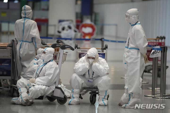 [베이징=AP/뉴시스] 2022 베이징 동계올림픽이 폐막한 후 21일(현지시간)베이징 국제공항에서 방호복을 입은 올림픽 관련 근로자들이 탑승객들의 탑승을 도운 후 카트에 앉아 쉬고 있다. 지난 4일 개막한 2022 베이징 동계올림픽이 17일간의 열전을 마치고 20일 폐막했다. 2022.02.21.