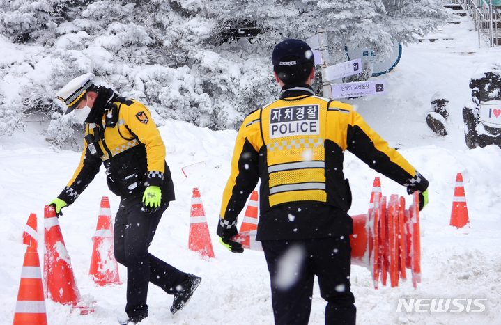 [제주=뉴시스] 우장호 기자 = 제주 서귀포시 1100고지 휴게소에서 교통정리에 나선 제주자치경찰단 소속 경찰관들이 눈이 내리는 추위 속에서 라바콘을 정리하느라 여념이 없다. (뉴시스DB) woo1223@newsis.com