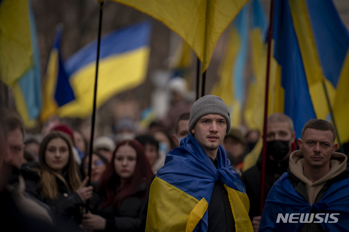 [오데사=AP/뉴시스] 20일(현지시간) 우크라이나 오데사에서 대형 우크라이나 국기를 든 시위대가 거리를 행진하고 있다. 오데사에서 8년 전 100여 명이 숨진 마이단 시위를 추념하며 수천 명의 시위대가 모여 단합된 모습을 보였다. 이들은 국기와 각종 구호가 적힌 팻말을 들고 러시아 침공에 반대하는 시위를 벌이며 유사시 도시를 지킬 준비가 돼 있다고 밝혔다. 2022.02.21.