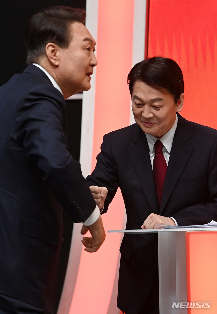 [서울=뉴시스] 국회사진기자단 = 윤석열 국민의힘 대선 후보와 안철수 국민의당 대선 후보가 21일 서울 마포구 MBC에서 열린 중앙선거관리위원회 주관 첫 토론회에서 인사를 나누고 있다. 2022.02.21. photo@newsis.com