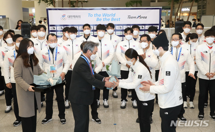 [인천공항=뉴시스] 조수정 기자 = 2022 베이징 동계올림픽에 출전했던 대한민국 선수단 대표 컬링 김은정, 스피드 스케이팅 차민규가 21일 오후 인천국제공항 제2터미널을 통해 귀국, 입국장에서 열린 환영행사에서 이기흥 대한체육회장으로부터 꽃다발을 받고 있다. 2022.02.21. chocrystal@newsis.com