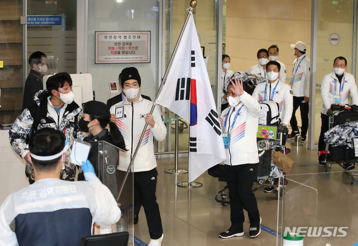 [인천공항=뉴시스] 조수정 기자 = 2022 베이징 동계올림픽에 출전했던 대한민국 선수단이 21일 오후 인천국제공항 제2터미널을 통해 귀국, 입국장에서 열린 환영행사장으로 향하고 있다. 태극기를 든 이는 스피드 스케이팅 차민규. 2022.02.21. chocrystal@newsis.com