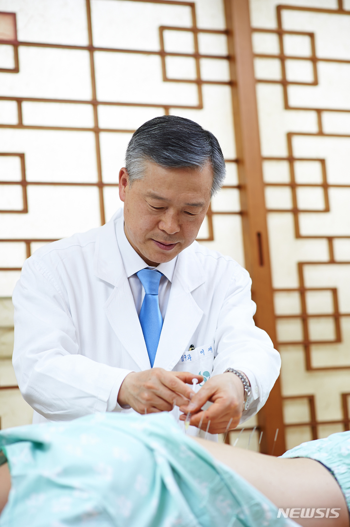 [서울=뉴시스] 이재동 경희대한의과대학 학장(비만센터 교수)이 환자를 대상으로 마이크로칩을 이용한 전자파 충격을 꿀벌에 가해 추출한 벌독을 주사제제로 정제해 침치료점인 경혈에 주입하는 '봉독약침' 요법을 시행하고 있다. (사진= 경희의료원 제공) 2022.02.22