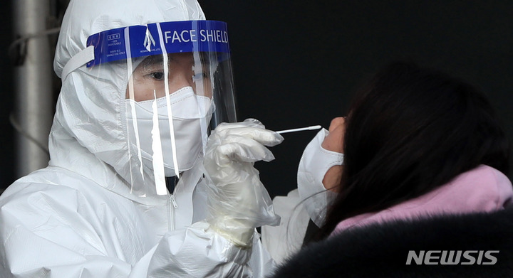 [서울=뉴시스] 추상철 기자 = 22일 오전 서울 중구 서울역광장 임시선별검사소에서 의료진이 코로나19 신속항원검사를 하고 있다. 2022.02.22. scchoo@newsis.com