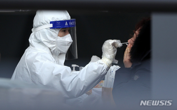 [서울=뉴시스] 추상철 기자 = 22일 오전 서울 중구 서울역광장 임시선별검사소에서 의료진이 코로나19 신속항원검사를 하고 있다. 2022.02.22. scchoo@newsis.com