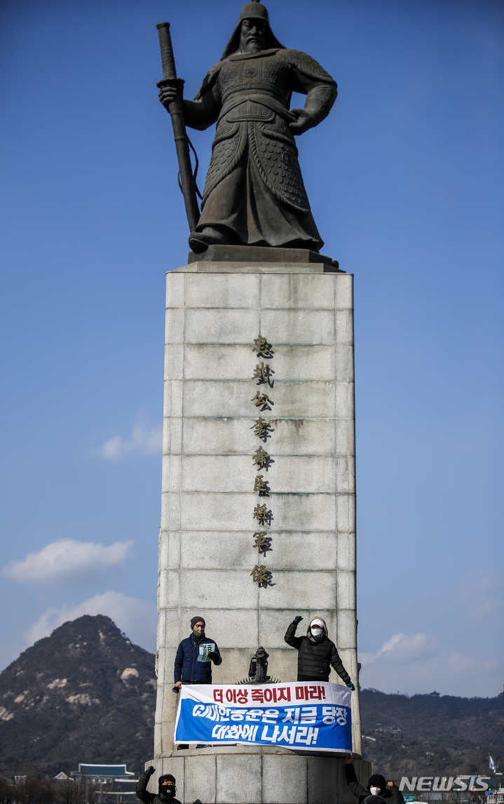 [서울=뉴시스] 정병혁 기자 = CJ대한통운 택배노동자들이 22일 오후 서울 종로구 이순신동상 위에서 CJ대한통운에 대화를 촉구하며 기습시위를 하고 있다. 2022.02.22. jhope@newsis.com