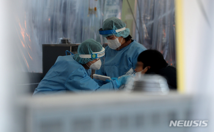 [서울=뉴시스] 추상철 기자 = 강추위가 이어진 23일 오전 서울 중구 서울광장 임시선별검사소에서 의료진이 코로나19 검사를 하고 있다. 2022.02.23. scchoo@newsis.com