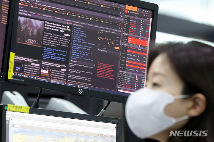 [서울=뉴시스] 백동현 기자 = 우크라이나 사태가 연일 계속되는 24일 오전 서울 중구 하나은행 본점 딜링룸에서 한 딜러가 관련 뉴스를 보고 있다. 2022.02.24. livertrent@newsis.com