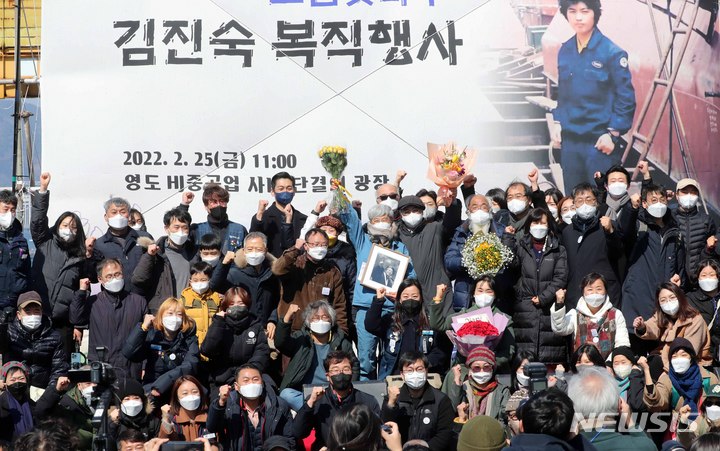 [부산=뉴시스] 하경민 기자 = 지난 37년간 복직투쟁을 벌인 김진숙 민주노총 부산본부 지도위원이 25일 부산 영도구 HJ중공업 영도조선소 광장에서 열린 명예 복직·퇴직 축하 행사에 참석해 축하하는 동료 등과 기념사진을 찍고 있다. 2022.02.25. yulnetphoto@newsis.com