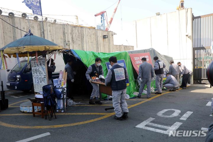 [부산=뉴시스] 하경민 기자 = 지난 37년간 복직투쟁을 벌인 김진숙 민주노총 부산본부 지도위원의 명예 복직·퇴직 축하 행사가 열린 25일 오후 부산 영도구 HJ중공업 영도조선소 정문 앞에서 노사 관계자들이 합동으로 농성장을 철거하고 있다. 2022.02.25. yulnetphoto@newsis.com