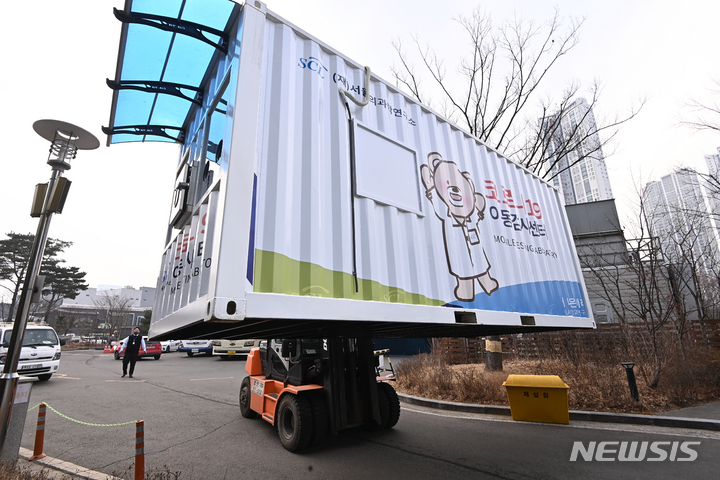 [용인=뉴시스] 김종택기자 = 지난달 25일 오후 경기도 용인시 서울의과학연구소에서 관계자들이 지게차로 이동형 유전자증폭(PCR) 검사소를 옮기고 있다. 이동형 PCR 검사소는 코로나19 집단감염이 발생한 학교에 투입돼 학생·교직원이 선별진료소에 갈필요 없이 현장에서 PCR 검사를 받을 수 있도록 지원한다. 2022.03.11. jtk@newsis.com
