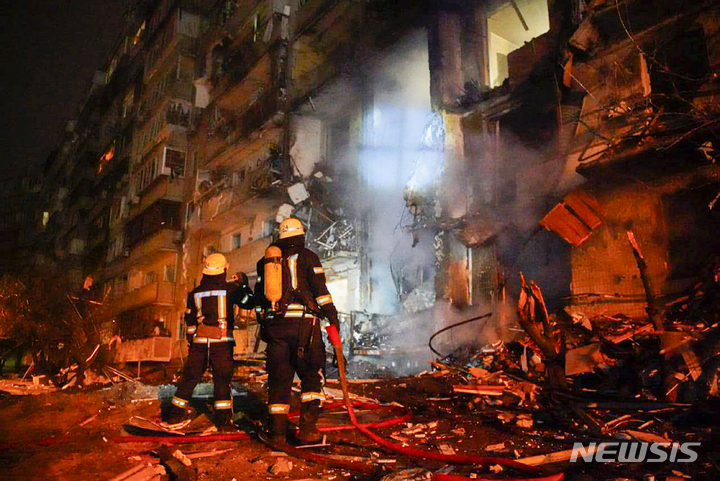 [키예프=AP/뉴시스]25일(현지시간) 우크라이나 키예프에서 소방관들이 미사일 공격을 받은 건물을 살펴보고 있다. 2022.2.25.