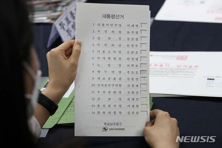 [서울=뉴시스] 조수정 기자 = 제20대 대통령선거를 11일 앞둔 지난 2월26일 서울 용산구 선거관리위원회에서 직원들이 거소투표용지 등 발송 작업 중 시각장애인을 위한 점자 '투표보조용구'를 확인하고 있다.&nbsp; 2022.02.26. chocrystal@newsis.com