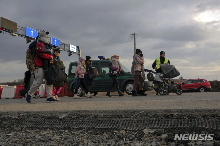 [메디카(폴란드)=AP/뉴시스]우크라이나와 국경을 맞대고 있는 폴란드 메디카의 검문소에 26일 러시아의 침공을 피해 탈출한 우크라이나 국민들이 도착하고 있다. 러시아의 침공 속에 수만명의 난민이 우크라이나를 떠나고 있는 가운데 이와 달리 유럽 전역에서 많은 우크라이나 남녀들이 조국 수호를 위해 우크라이나로 돌아오고 있다. 2022.2.27