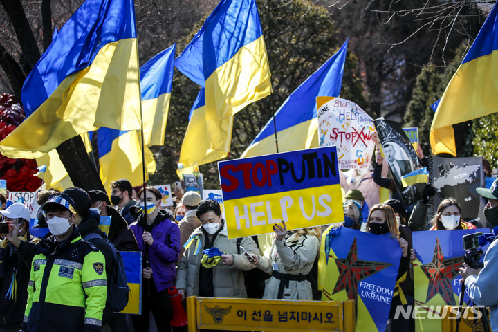 [서울=뉴시스] 정병혁 기자 = 재한 우크라이나인들이 27일 오전 서울 중구 러시아대사관 인근에서 러시아의 우크라이나 침공 규탄 시위를 열고 피켓을 들고 있다. 2022.02.27. jhope@newsis.com