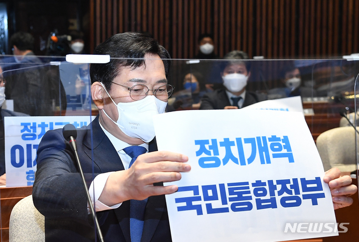 [서울=뉴시스] 최진석 기자 = 송영길 더불어민주당 대표가 27일 서울 여의도 국회에서 열린 더불어민주당 의원총회에서 ‘정치개혁 국민통합정부’ 푯말을 자리 앞에 놓고 있다. 당일 의총에서는 국민통합 정치개혁안 등이 논의됐다. (공동취재사진) 2022.02.27. photo@newsis.com