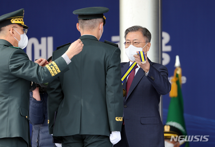 [영천=뉴시스] 김진아 기자 = 문재인 대통령이 28일 경북 영천시 육군3사관학교에서 열린 제57기 졸업 및 임관식에서 우등상 수상자인 김재현 사관생도에게 우등메달을 목에 걸어주고 있다. 2022.02.28. bluesoda@newsis.com