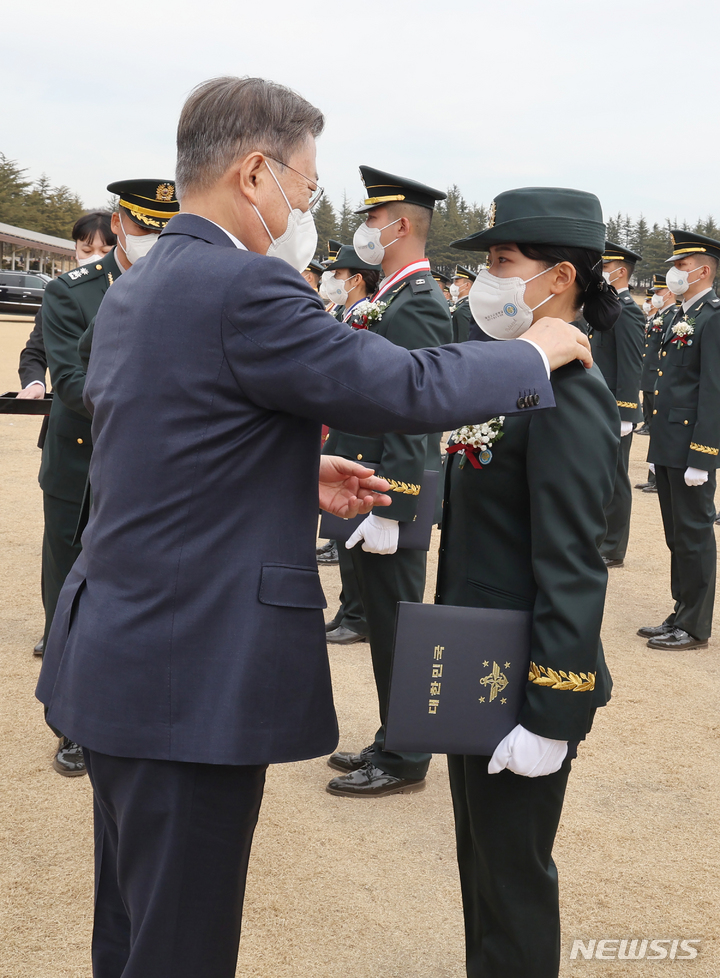 [영천=뉴시스] 김진아 기자 = 문재인 대통령이 28일 경북 영천시 육군3사관학교에서 열린 제57기 졸업 및 임관식에서 임관장교에게 계급장을 수여하고 있다. 2022.02.28. bluesoda@newsis.com