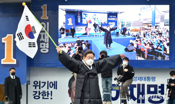 [대구=뉴시스] 이무열 기자 = 이재명 더불어민주당 대선 후보가 28일 오후 대구 동구 동대구역 광장에서 열린 유세에서 3·1절을 맞아 선물 받은 두루마기를 입고 태극기를 휘날리고 있다. 2022.02.28. lmy@newsis.com