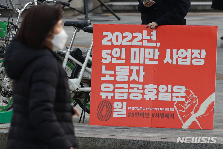 [서울=뉴시스] 권창회 기자 = 지난해 2월28일 오후 서울 중구 서울고용노동청 앞에서 열린 '모두의 빨간날, 모두의 투표권 보장 5인미만 차별폐지 공동행동의 날'에서 참석자들이 1인 피켓 시위를 하고 있다. 2022.02.28. kch0523@newsis.com