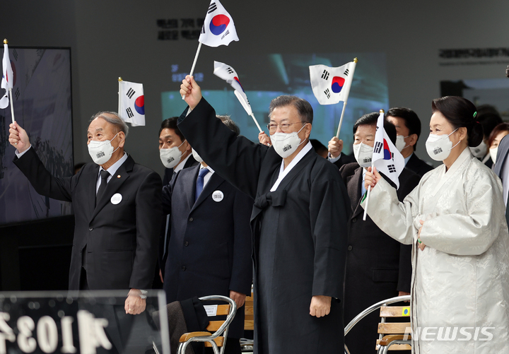[서울=뉴시스] 김진아 기자 = 문재인 대통령과 김정숙 여사가 1일 서울 서대문구 국립 대한민국임시정부 기념관에서 열린 제103주년 3.1절 기념식에서 참석자들과 만세삼창을 마친 뒤 태극기를 흔들고 있다. 2022.03.01. bluesoda@newsis.com