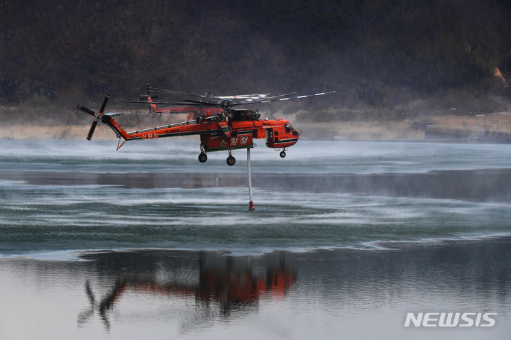 [합천=뉴시스] 차용현 기자 = 지난 28일 경남 합천군에서 발생한 산불이 경북 고령군 쌍림면까지 번진 가운데 1일 오전 합천군 핫들생태공원 인근 강에서 산림청 소속 산불진화헬기가 물을 채우고 있다 2022.03.01. con@newsis.com