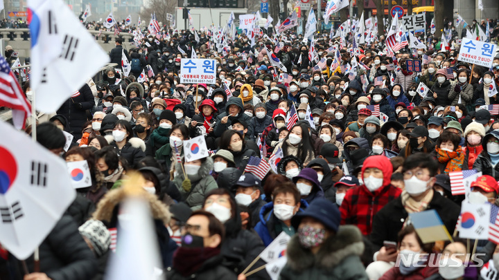 [서울=뉴시스] 이영환 기자 = 1일 오후 서울 중구 청계광장에서 사랑제일교회가 주최한 2022 3·1절 광화문 1천만 국민기도회에서 참가자들이 태극기와 성조기를 흔들고 있다. 2022.03.01. 20hwan@newsis.com