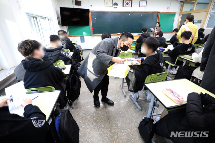 [서울=뉴시스] 조수정 기자 = 전국 초·중·고교 개학 날인 2일 오전 서울 강남구 도곡중학교에서 한 학생이 지급받은 코로나19 자가검사키트를 살펴보고 있다. (공동취재사진) 2022.03.02. chocrystal@newsis.com