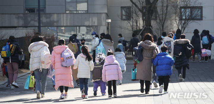 [서울=뉴시스] 권창회 기자 = 새학기 전면 등교 첫날인 지난 2일 오후 서울 시내 초등학교에서 학생들이 학부모들과 하교하고 있다. 2022.03.03. kch0523@newsis.com