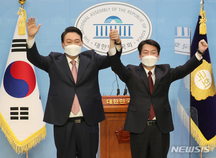 [서울=뉴시스] 김선웅 기자 = 야권 단일화에 전격 합의한 국민의힘 윤석열 대선 후보와 국민의당 안철수 대선 후보가 3일 오전 서울 여의도 국회 소통관에서 공동 기자회견을 마친 뒤 함께 손을 들어 올리고 있다. (공동취재사진) 2022.03.03. photo@newsis.com