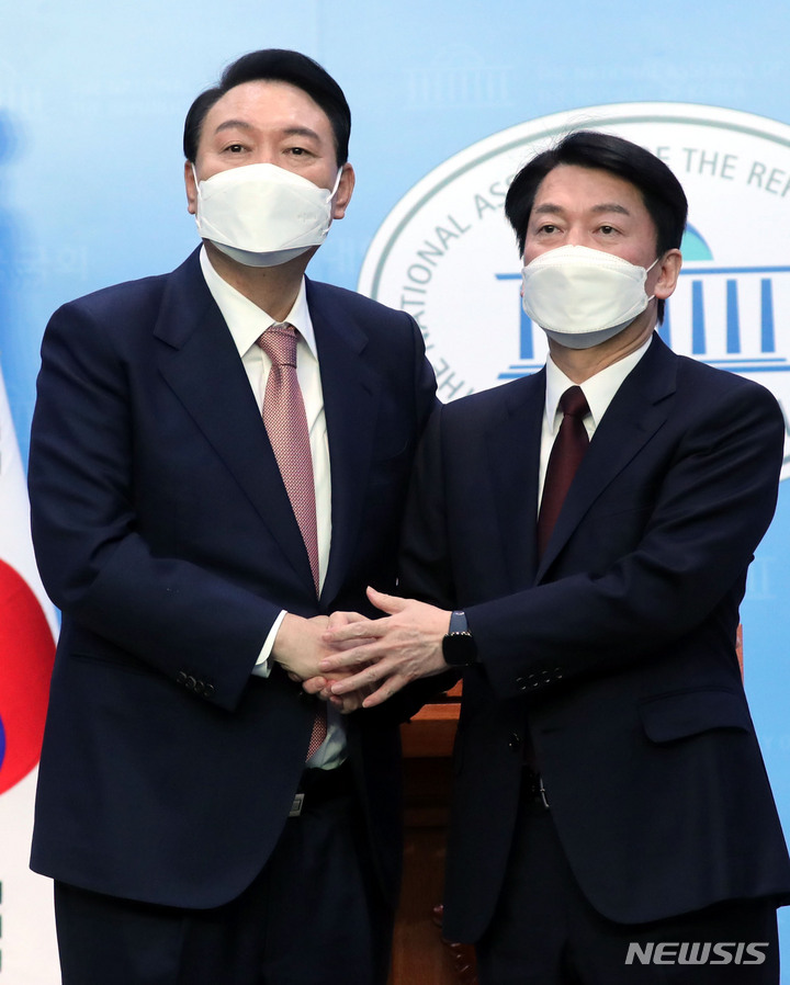 [서울=뉴시스] 최동준 기자 = 윤석열 국민의힘 대선 후보, 안철수 국민의당 대선 후보가 3일 서울 여의도 국회 소통관에서 단일화 기자회견을 마치고 악수하고 있다. (공동취재사진) 2022.03.03. photo@newsis.com