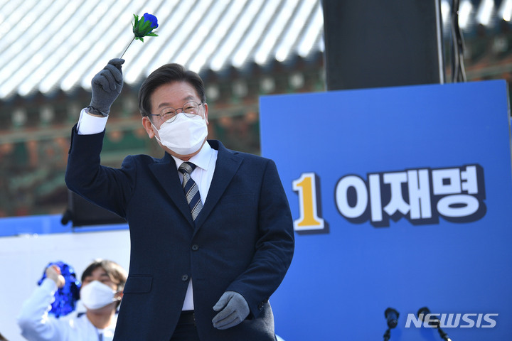 [서울=뉴시스] 국회사진기자단 = 이재명 더불어민주당 대선 후보가 3일 서울 종로구 보신각에서 열린 '우리 모두를 위해, 성평등 사회로' 유세에서 파란장미를 들고 인사하고 있다. 2022.03.03. photo@newsis.com
