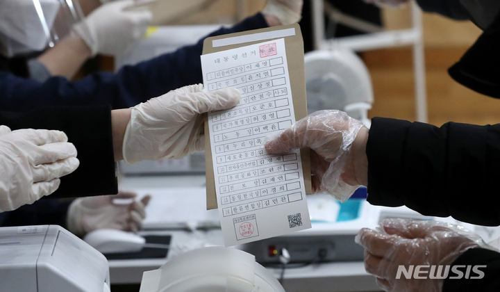 [서울=뉴시스] 백동현 기자 = 제20대 대통령선거 사전투표가 시작된 4일 오전 서울 서초구 반포1동 주민센터에 마련된 사전투표소에서 관계자가 안철수 국민의당 대표와 김동연 전 경제부총리 투표란에 '사퇴' 표시된 투표지를 전달하고 있다. 2022.03.04. livertrent@newsis.com