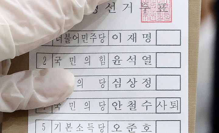 [서울=뉴시스] 백동현 기자 = 제20대 대통령선거 사전투표가 시작된 4일 오전 서울 서초구 반포1동 주민센터에 마련된 사전투표소에서 관계자가 안철수 국민의당 후보 투표란에 '사퇴' 표시된 투표지를 전달하고 있다. 2022.03.04. livertrent@newsis.com