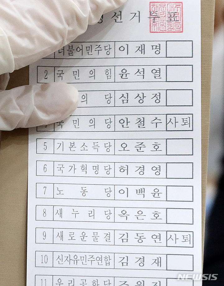 [서울=뉴시스] 백동현 기자 = 제20대 대통령선거 사전투표가 시작된 4일 오전 서울 서초구 반포1동 주민센터에 마련된 사전투표소에서 관계자가 안철수 국민의당 대표와 김동연 전 경제부총리 투표란에 '사퇴' 표시된 투표지를 전달하고 있다. 2022.03.04. livertrent@newsis.com