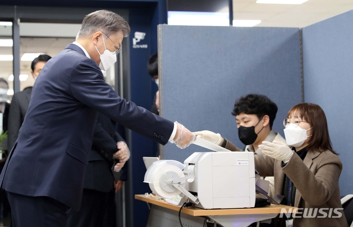 [서울=뉴시스] 전진환 기자 = 문재인 대통령이 제20대 대통령선거 사전투표 첫날인 4일 오전 서울 종로구 삼청동 주민센터에 마련된 투표소에서 투표용지를 받고 있다. 2022.03.04. amin2@newsis.com